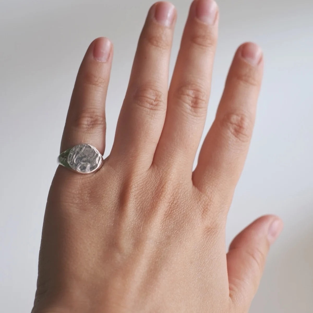 Bryzhi textured sterling silver signet ring worn on hand
