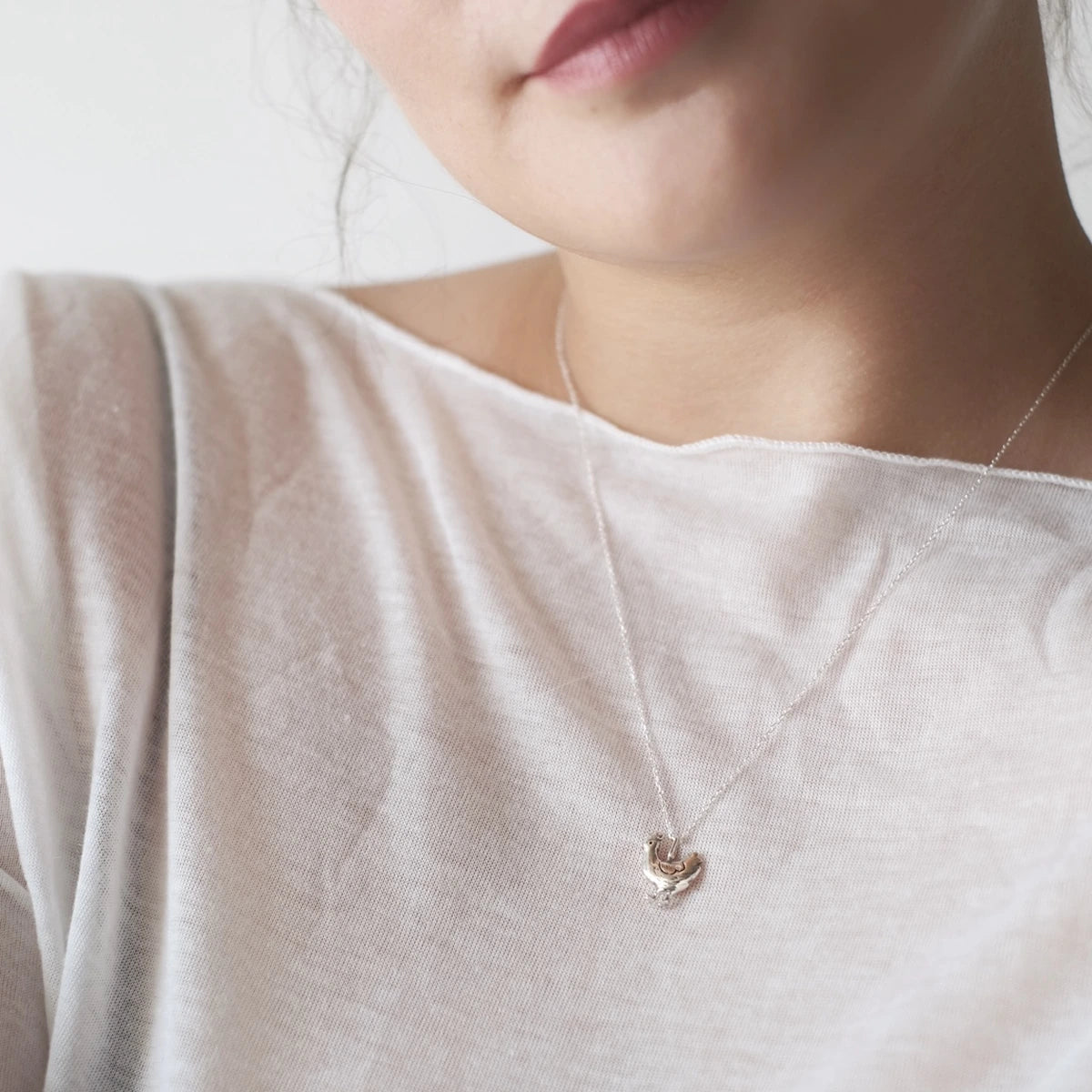 Co-Co handmade sterling silver chicken pendant with chain worn around the neck